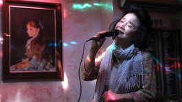 Film still from Poetry (2010). Image of an older woman singing at karaoke.